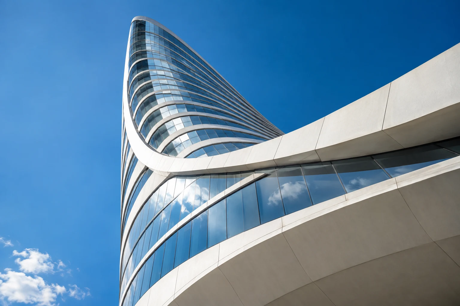 Sculptural modern office building curving toward a clear blue sky